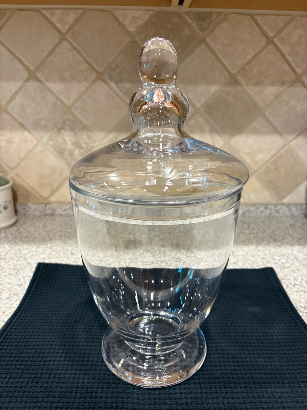 Clear glass footed apothecary jar with a matching knobbed lid